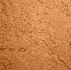 Close-up of a textured brown surface that resembles cocoa powder or a fine soil, showing an uneven and crumbly appearance.