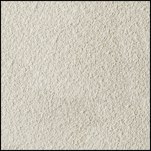 A close-up view of a textured, light beige, sandy surface with fine, granular particles evenly spread across the image.