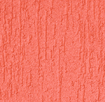 A close-up of a textured surface painted in a coral pink color, with vertical grooves and rough patterns resembling stucco or plaster.