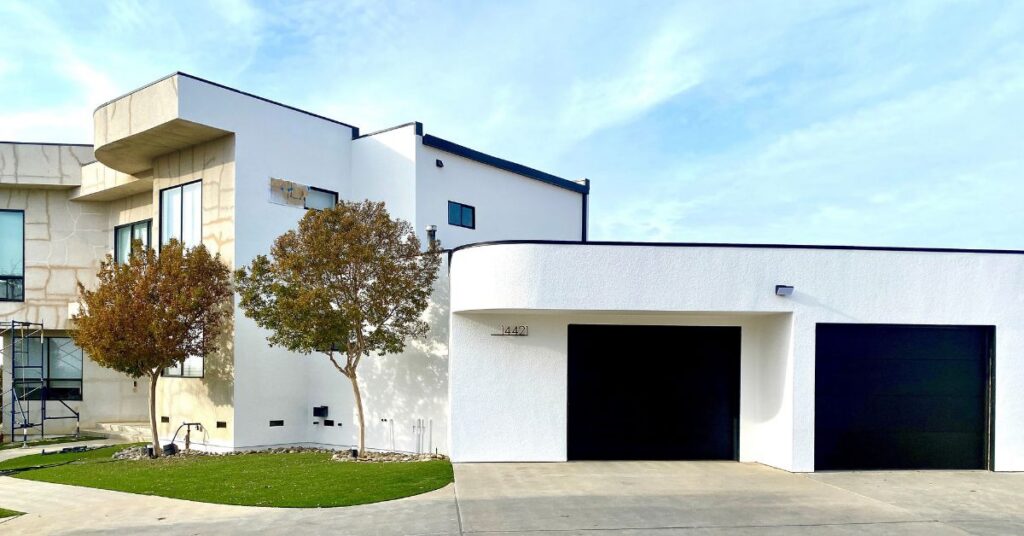 White modern house with scaffolding near the front entrance.