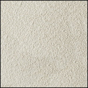 A close-up view of a textured, light beige, sandy surface with fine, granular particles evenly spread across the image.
